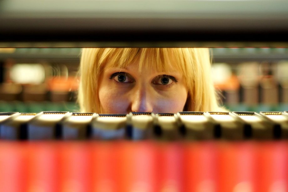 Studentin blickt durch Bücherregal

