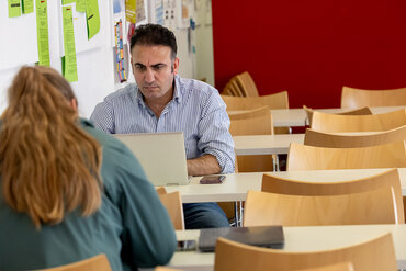 Ein Student sitzt konzentriert vor seinem Laptop.